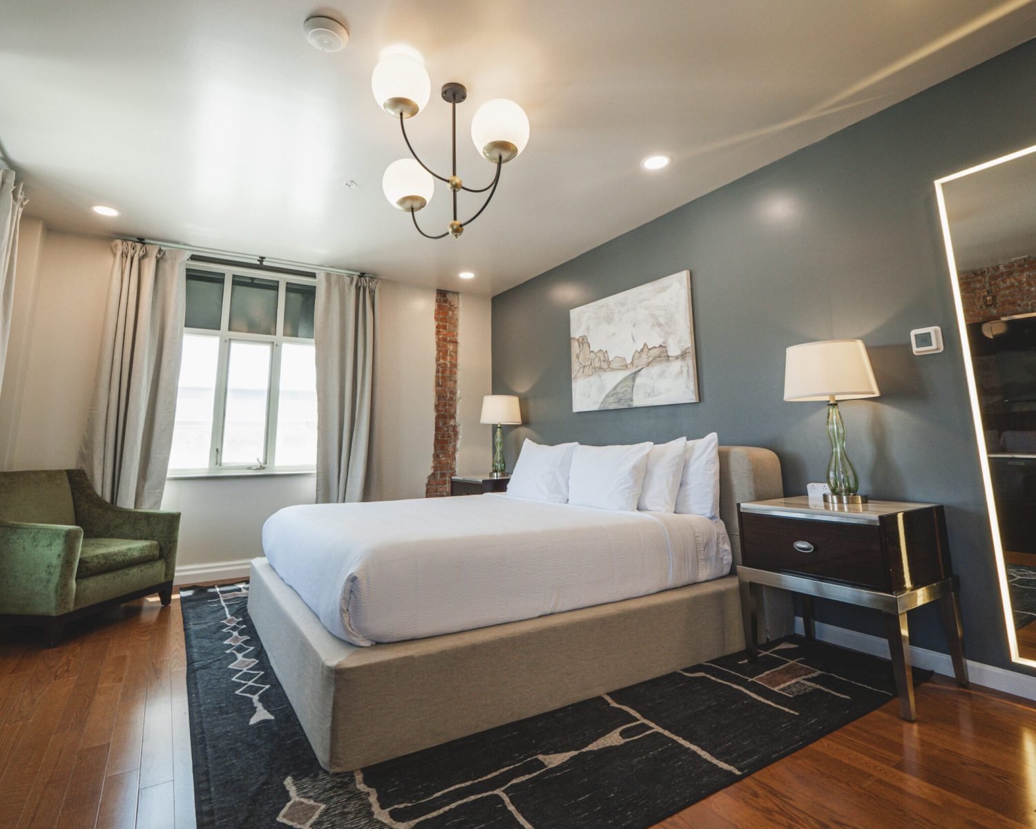 the-everett-suite-king-bed-room-with-oversized-mirror-and-exposed-brick-powerhouse-on-broadway