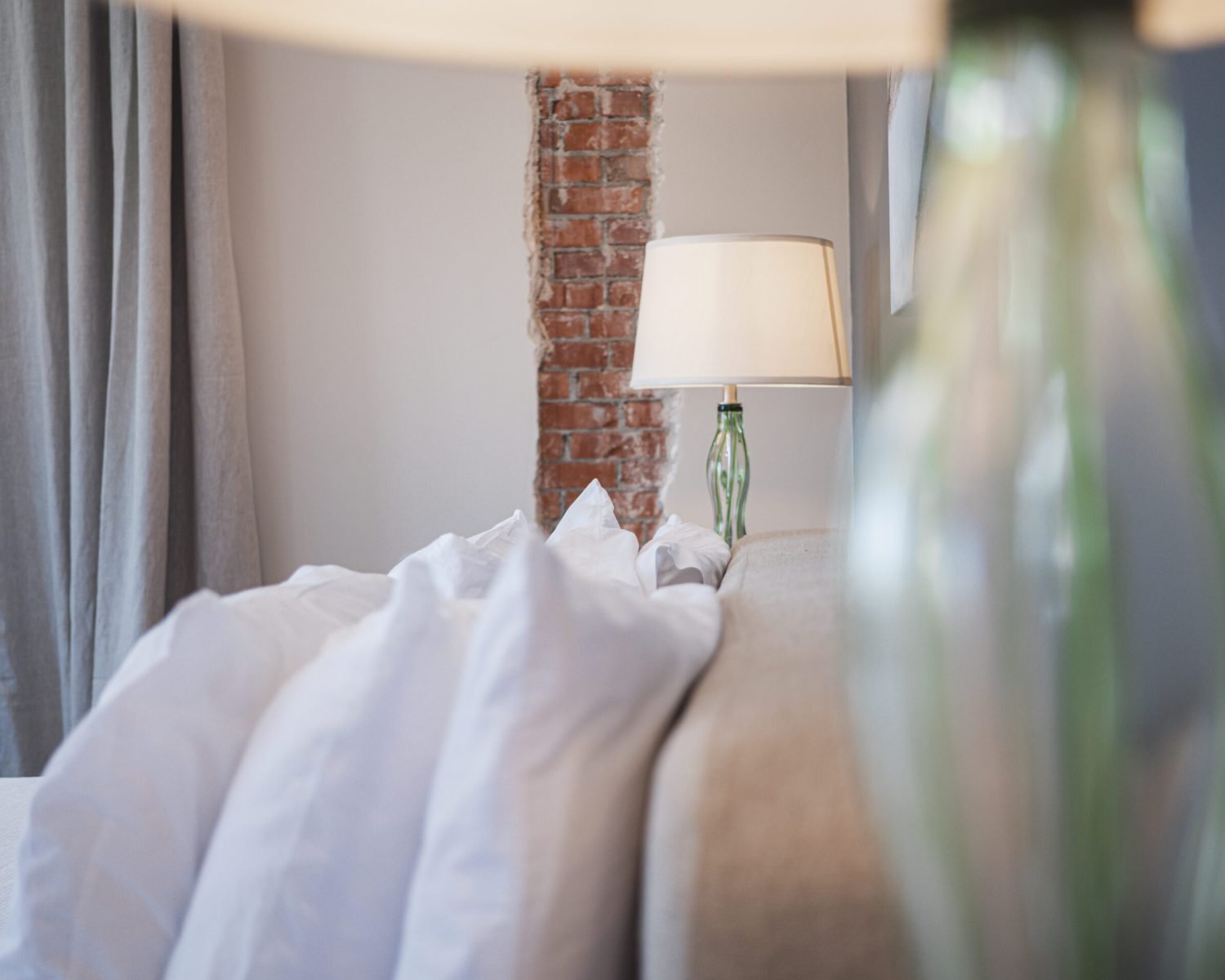 the-everett-suite-pillow-and-lamp-detail-with-exposed-brick-powerhouse-on-broadway
