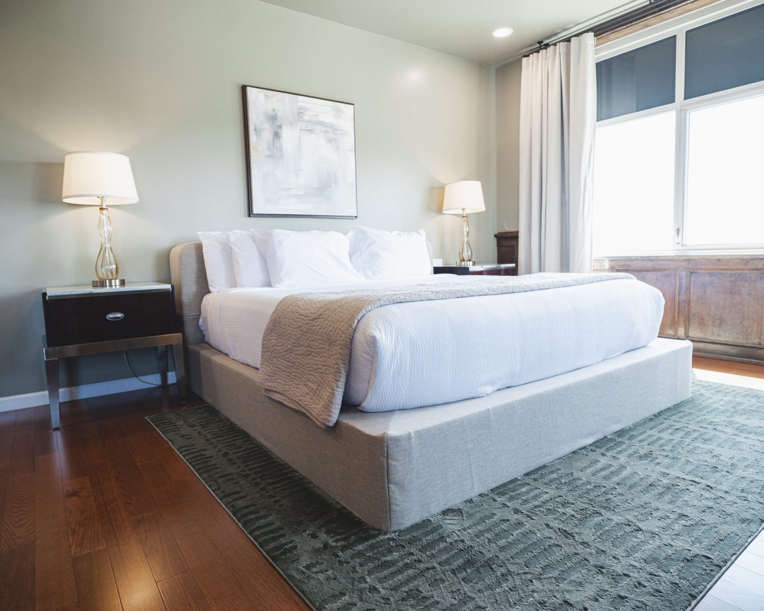 the-ford-suite-angled-king-bed-view-nightstands-artwork-soft-green-walls-and-window-light-powerhouse-on-broadway