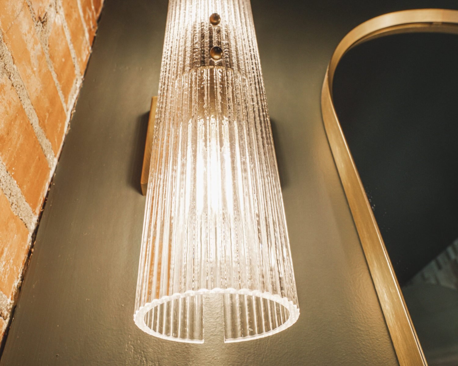 the-ford-suite-bathroom-sconce-light-on-brick-wall-powerhouse-on-broadway