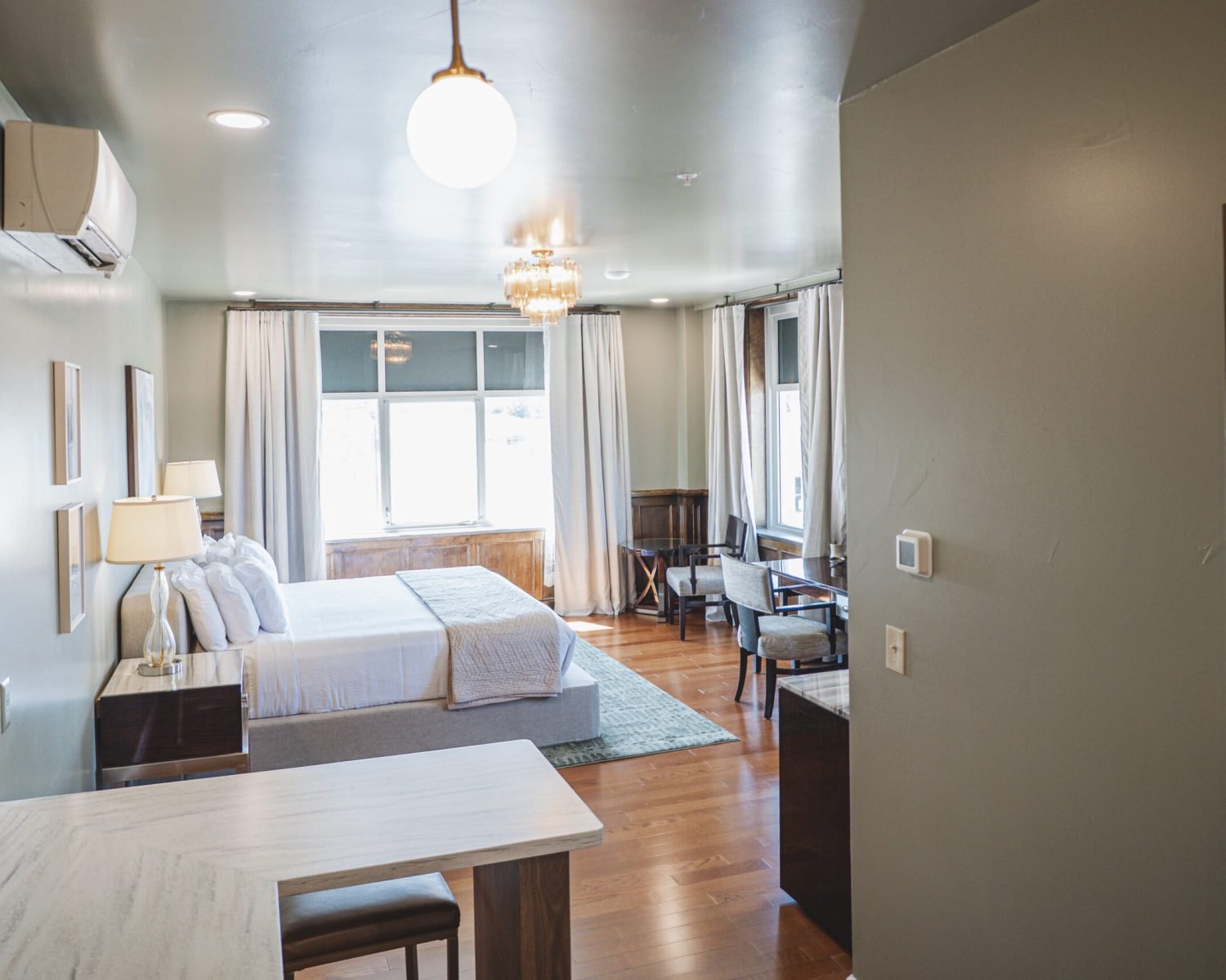 the-ford-suite-entry-view-full-room-layout-soft-green-walls-natural-light-crystal-lighting-powerhouse-on-broadway