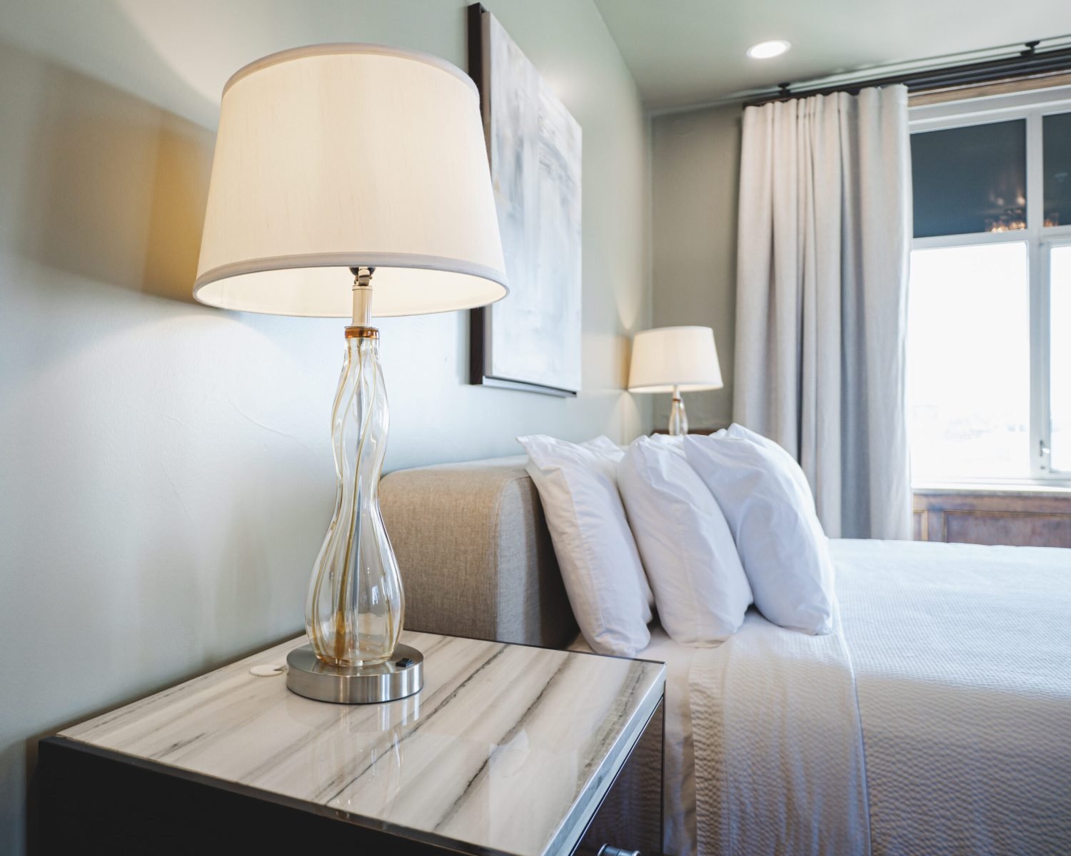 the-ford-suite-nightstand-with-glass-lamp-and-natural-light-bedroom-view-powerhouse-on-broadway