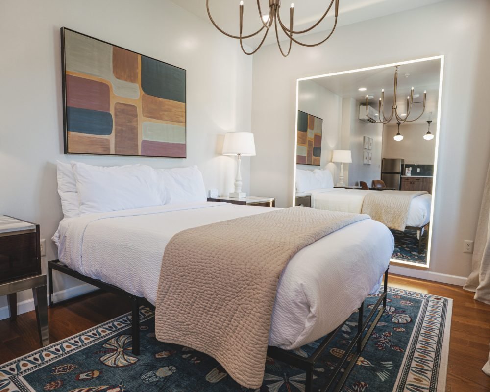 the-marguerite-suite-bedroom-modern-chandelier-abstract-wall-art-backlit-mirror-cozy-bed-powerhouse-on-broadway